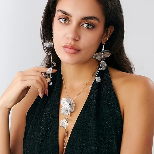 Model in a black halter dress wearing the gold ginkgo leaf tassel necklace