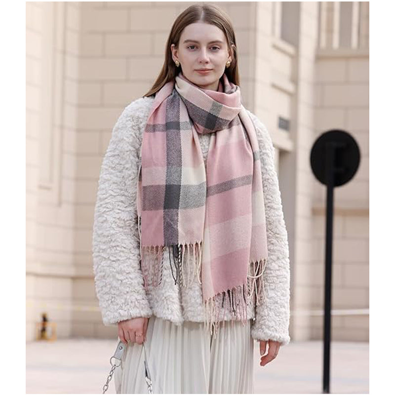 Woman wearing the blue plaid tassel scarf over a white sweater
