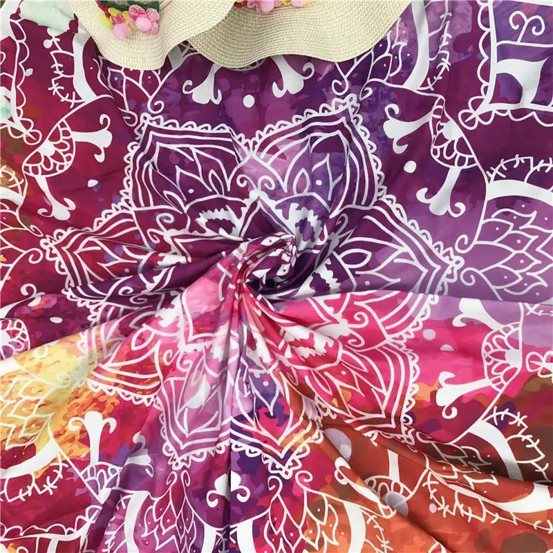 Floral beach blanket spread on sand