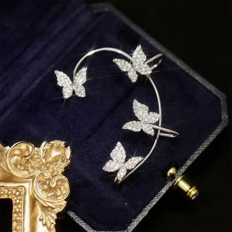 Gold-tone butterfly ear cuff with rhinestones on dark velvet