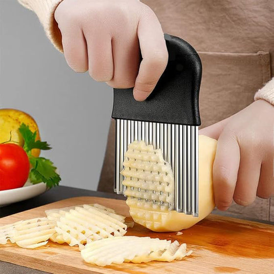 Crinkle cutter slicing a potato on a cutting board