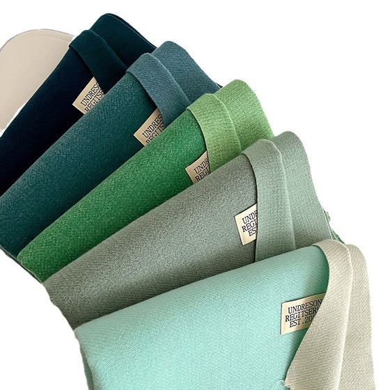 Stack of green and teal double-sided scarves