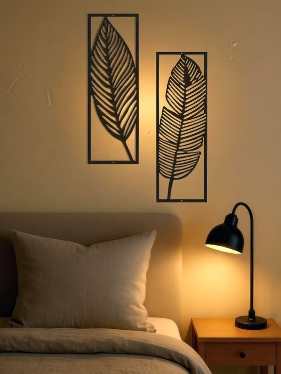 Leaf wall art panels above a bed in warm light