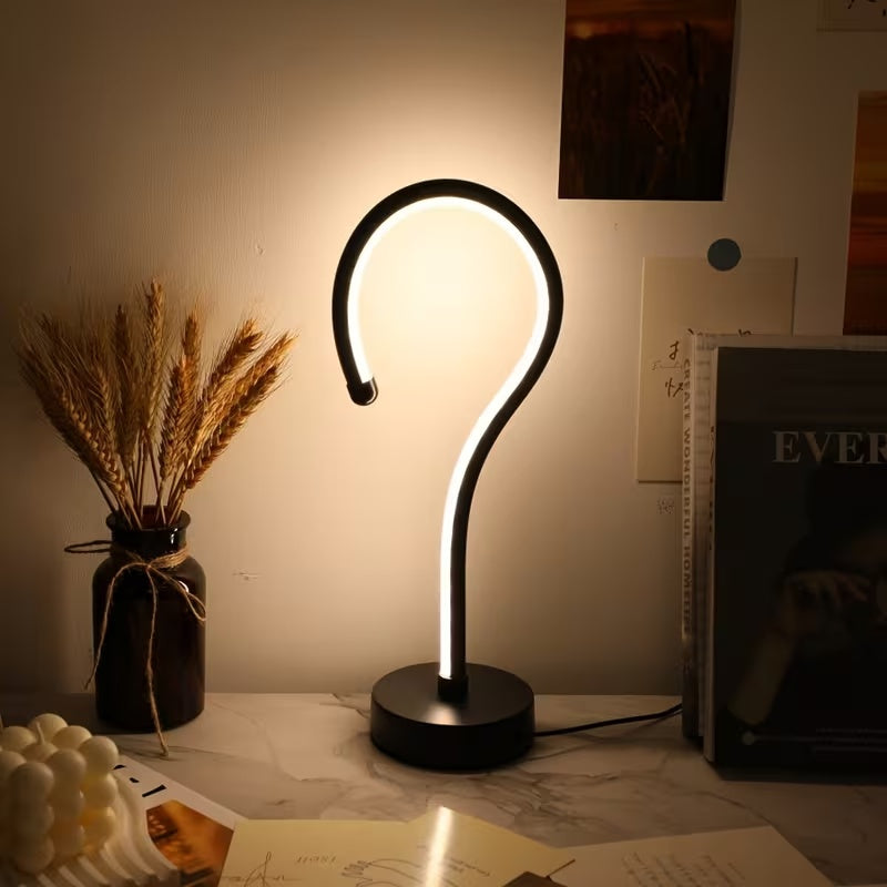 Question mark lamp glowing neutral white on a desk