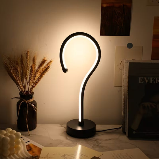 Question mark lamp glowing neutral white on a desk