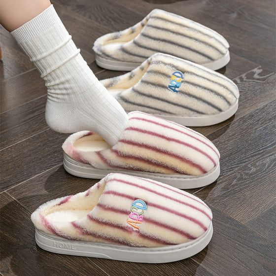 Person in white socks stepping into striped plush slippers