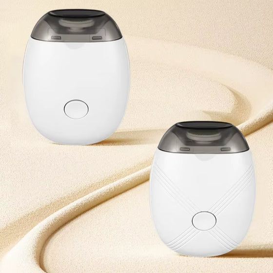 Two white egg-shaped electric pet nail grinders on a sand-colored background