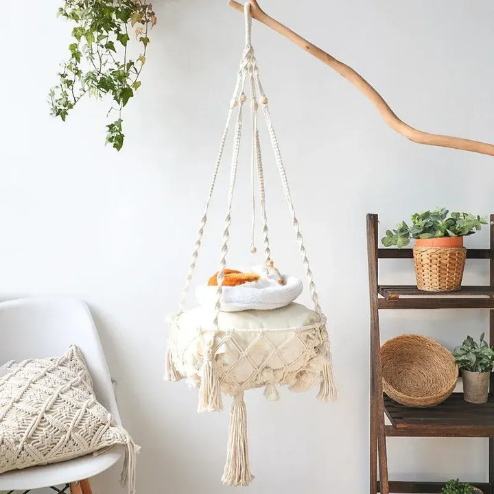 Macrame-style hanging cat hammock with a woven diamond rope pattern, wooden beads, and a round cushioned base