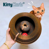 Accordion-fold cardboard spiral scratcher with a red perforated ball toy nested in the center track