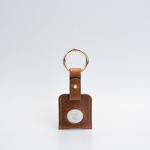 Leather AirTag keychain case showing snug AirTag fit