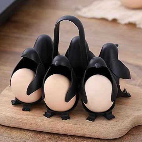 Penguin egg holder holding eggs upright on a wood cutting board, side view