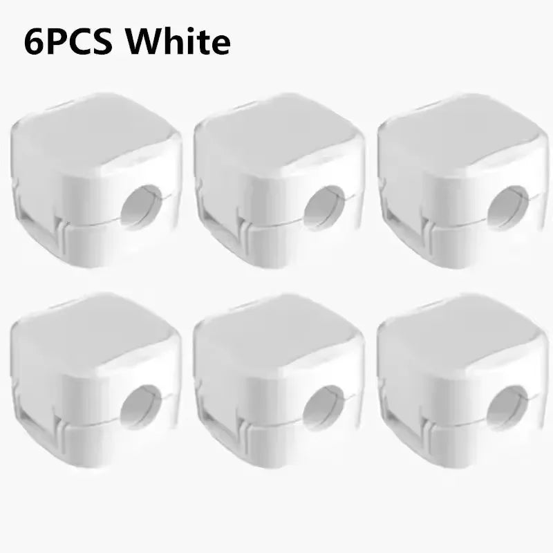 Magnetic cable clips holding charging cables on a desk