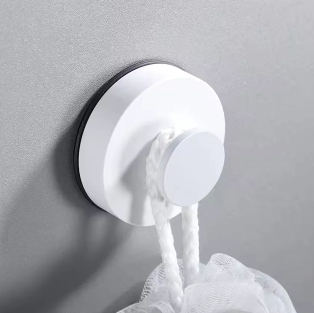 Suction hook mounted on a kitchen tile backsplash holding a utensil