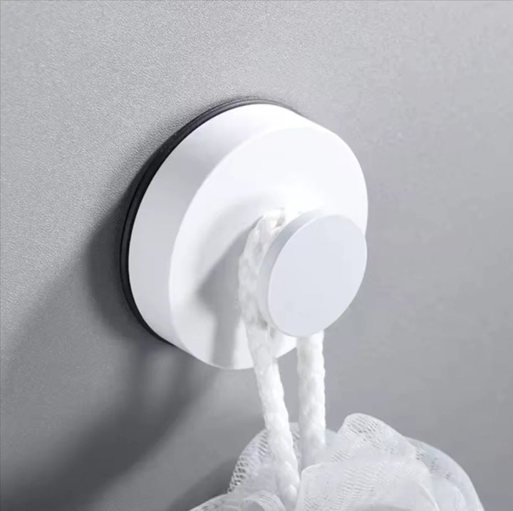 Suction hook mounted on a kitchen tile backsplash holding a utensil