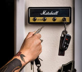 Wall-mounted key holder box with jack-socket style hooks and a car fob key hanging