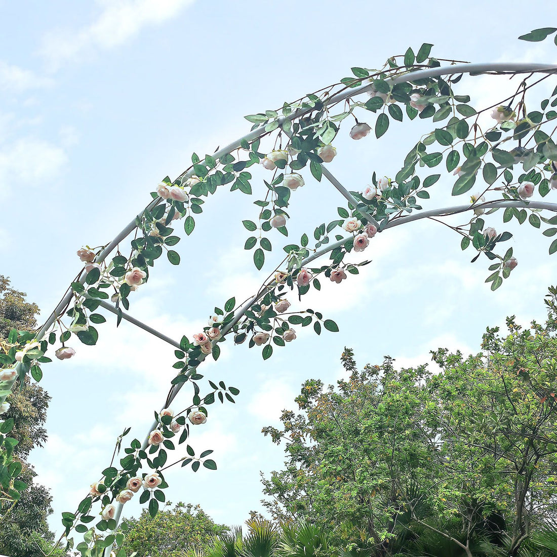 White metal garden arch trellis arbor with climbing plants over walkway - in-use lifestyle