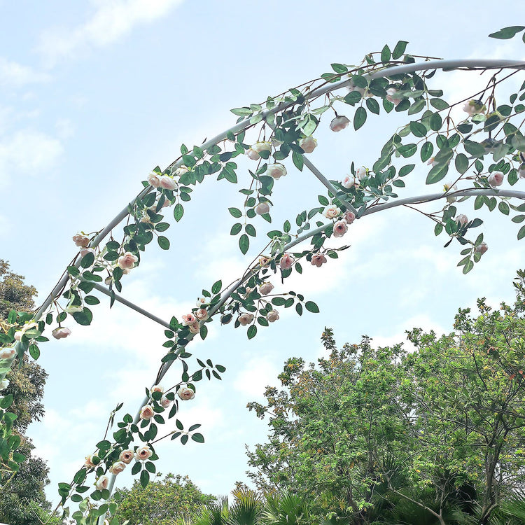 White metal garden arch trellis arbor with climbing plants over walkway - in-use lifestyle