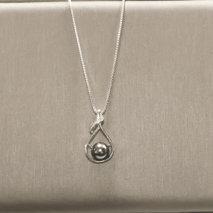 Black pearl necklace worn with neutral top, lifestyle view