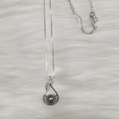 Black pearl necklace flat lay on light background