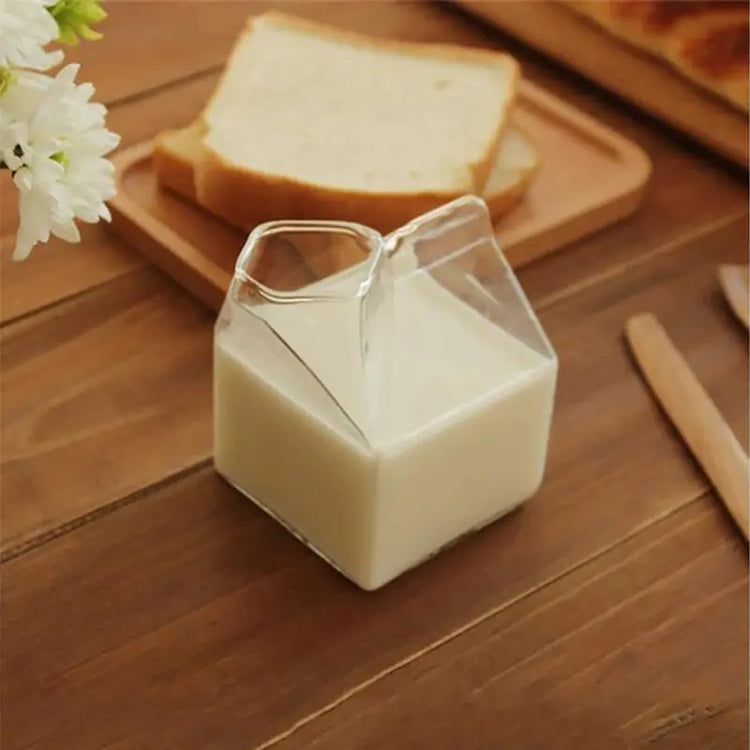 Clear glass drinking cup molded to resemble a folded milk carton with a gable-top peaked seam at the lid