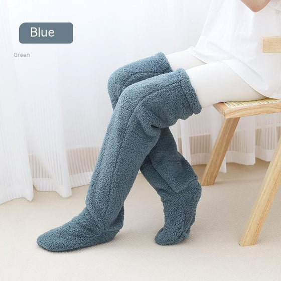 Dark blue fuzzy knee-high socks worn while seated on a chair