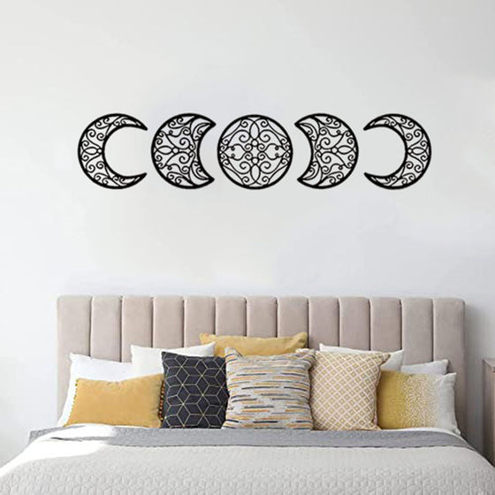 Moon phase wall art above a bed