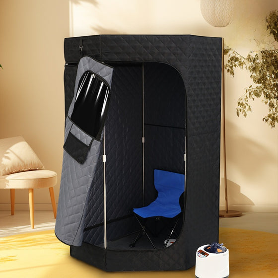 Black quilted steam sauna tent with a blue folding chair and a steamer