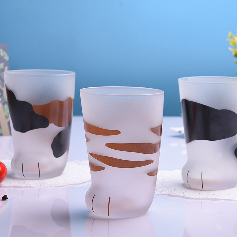 Tabby and cow print cat paw glass mugs on a blue background