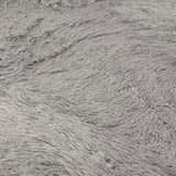 Grey shag rug shown under a small sectional