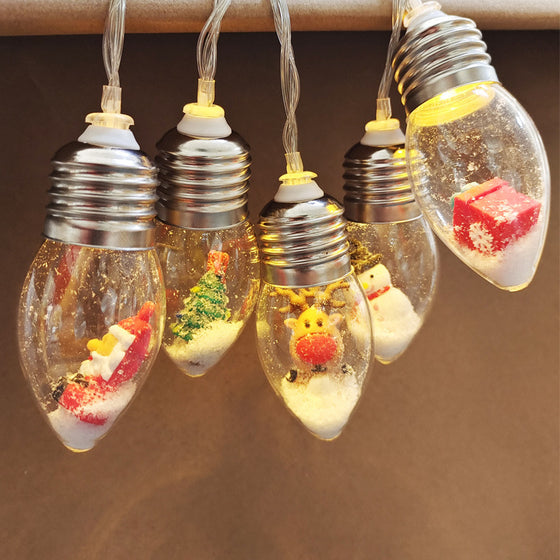 Christmas character bulb string lights hung on a tree with assorted figures