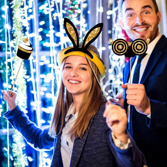 Couple posing with bunny ears and glasses photo booth props at a party