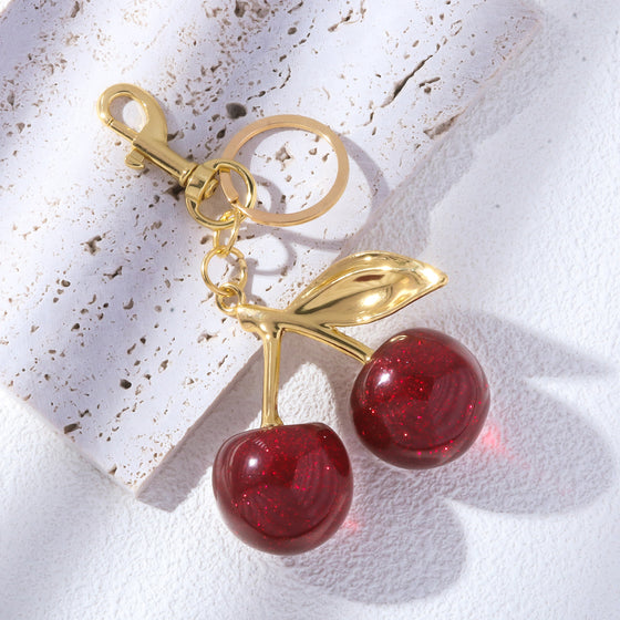 Red cherry keychain with gold leaf on white lace