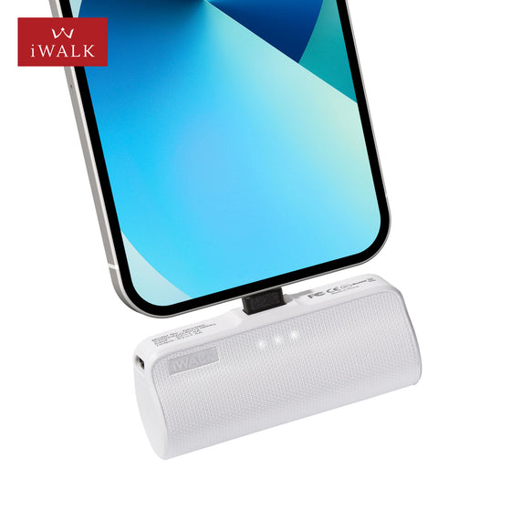 White mini power bank plugged into the bottom of a phone