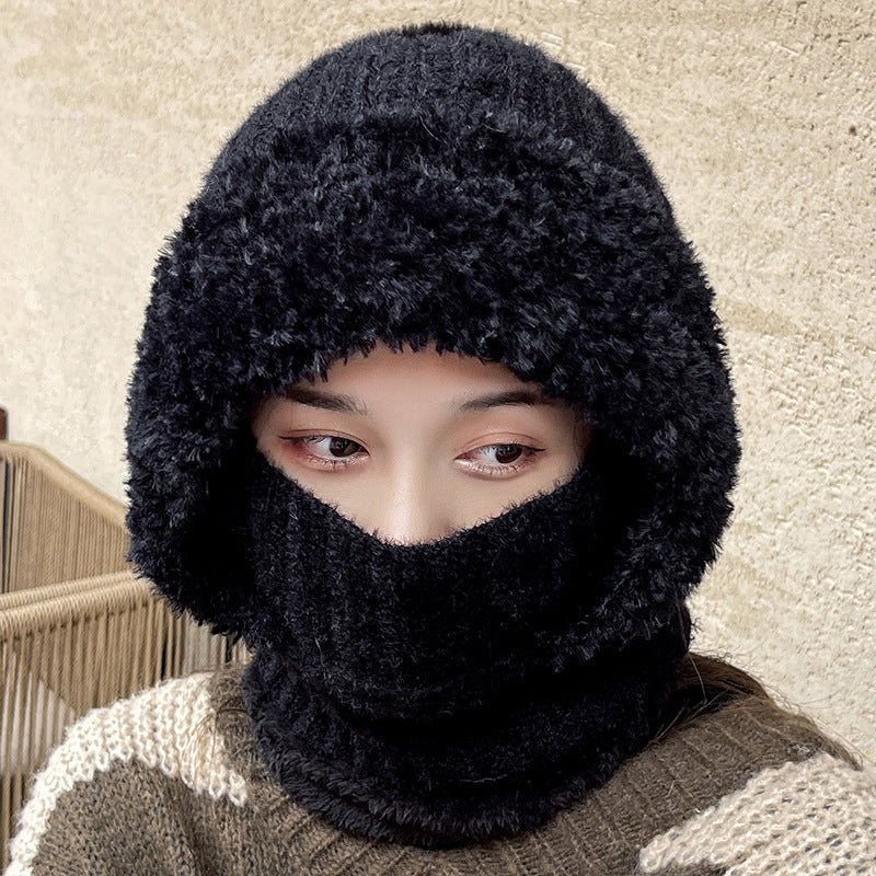 Woman wearing a black knit hood with the neck section over her nose