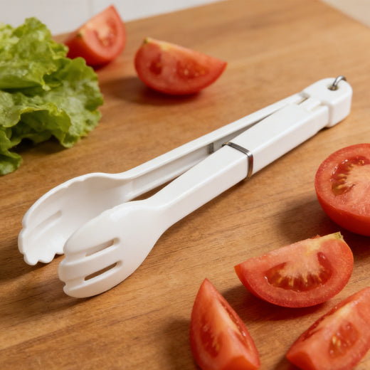 Salad tongs serving pasta at table