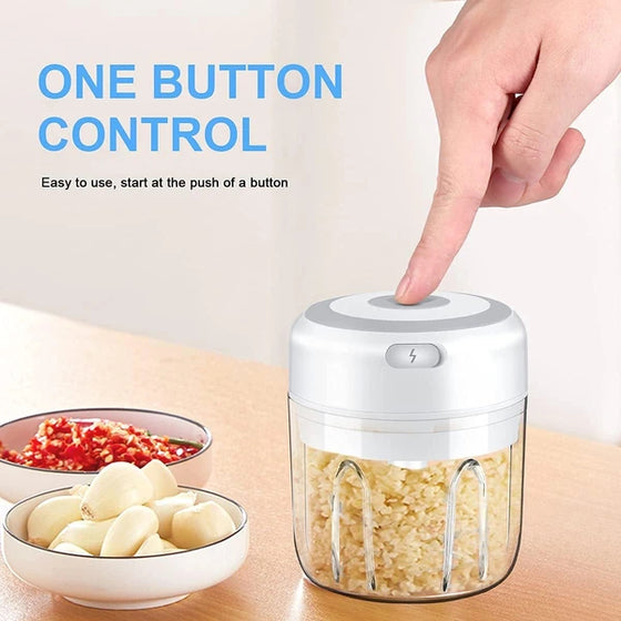 Finger pressing the button on a chopper full of minced garlic