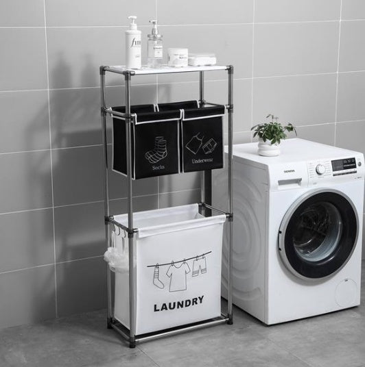 Laundry sorter with black and white bags beside a washing machine