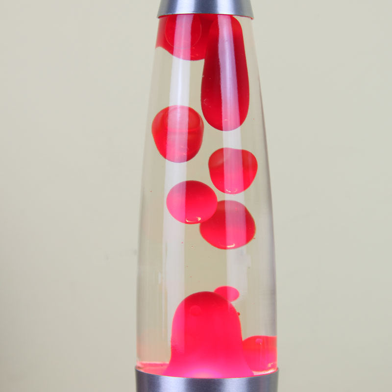 Close-up of red wax blobs floating in the glass bottle