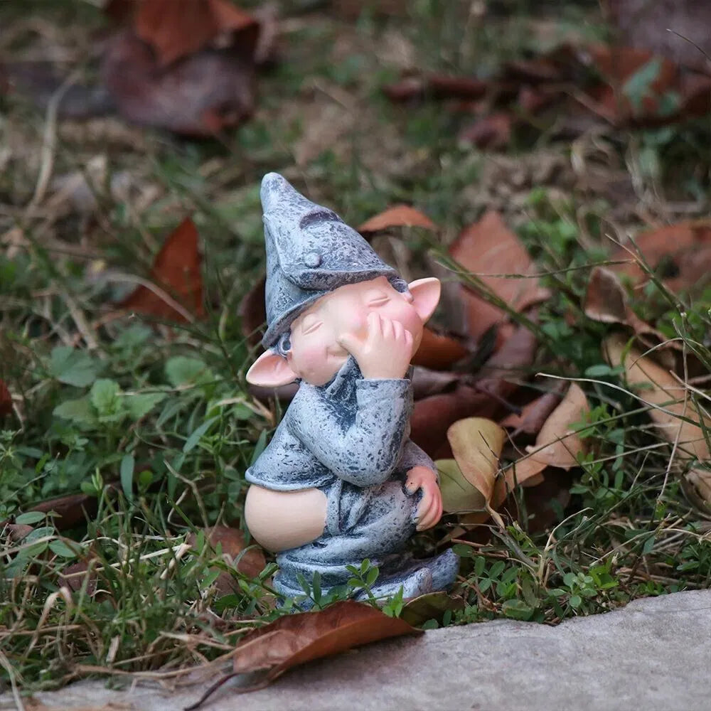Funny pooping gnome lawn ornament in fallen leaves outdoors