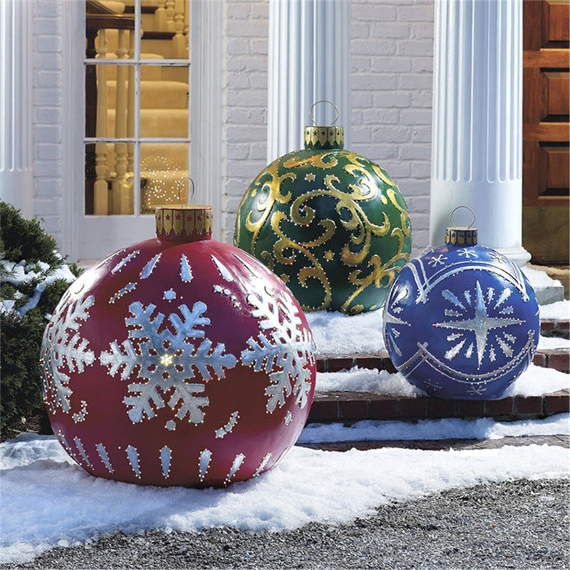 Red snowflake, blue and green giant inflatable ornaments beside a front door