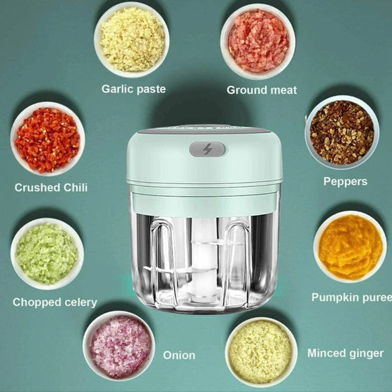 Green mini chopper surrounded by bowls of chopped foods