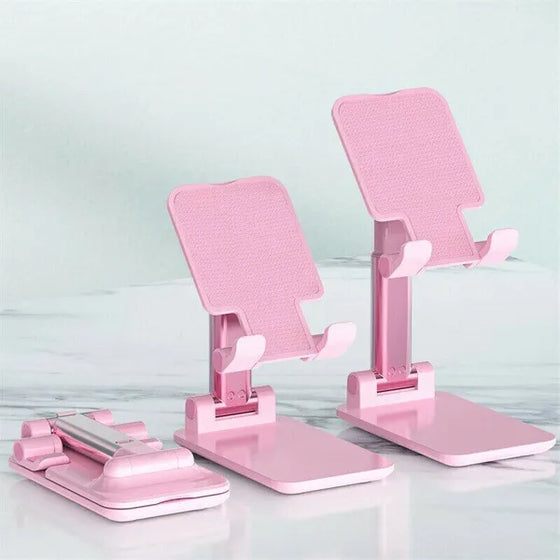 Two pink foldable desktop phone and tablet stands on a white surface