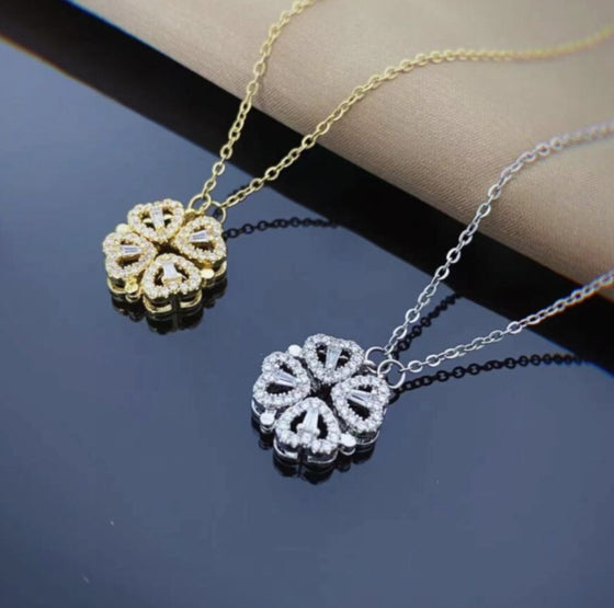 Gold-tone and silver-tone clover pendants on a dark background