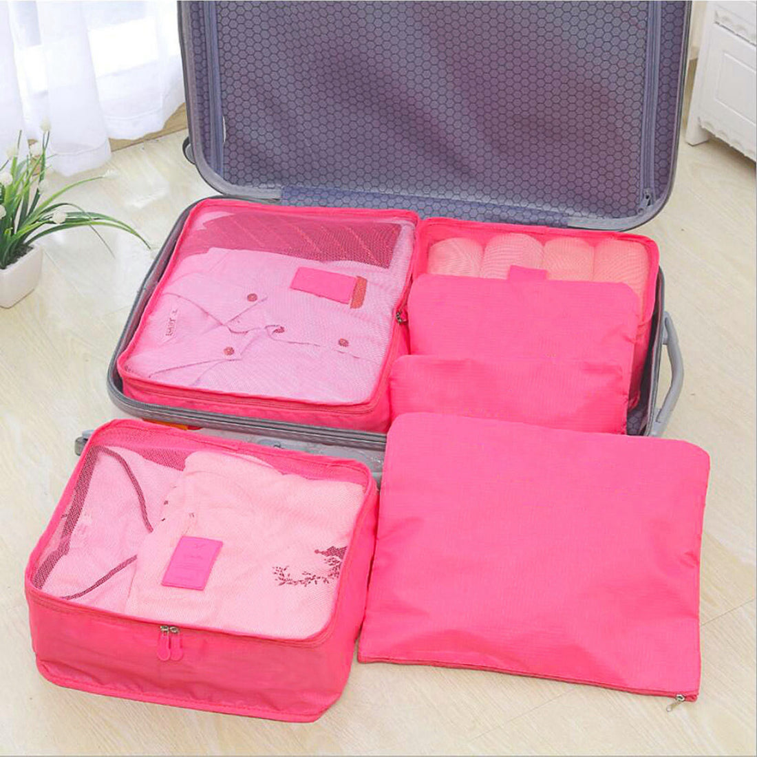Hot pink packing cubes inside an open suitcase