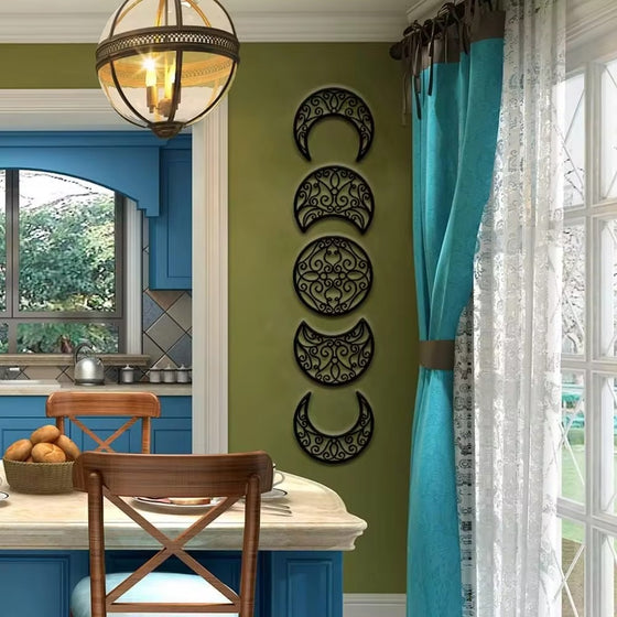 Moon phase pieces hung vertically on a green wall