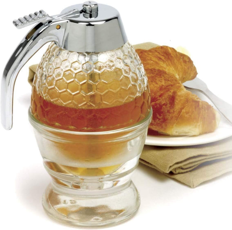 Syrup dispenser pouring honey on pancakes