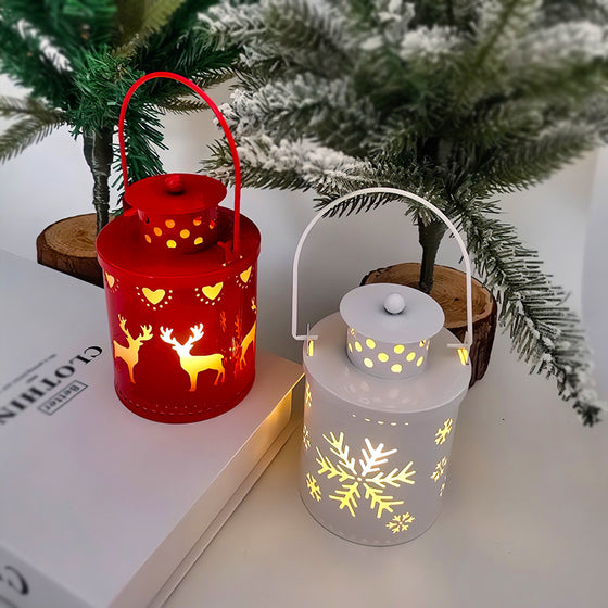 Red and white battery operated Christmas lanterns glowing beside mini Christmas trees