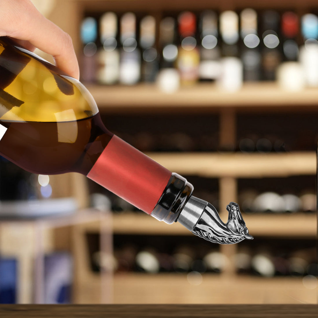 Silver horse head stopper sealing a wine bottle being poured