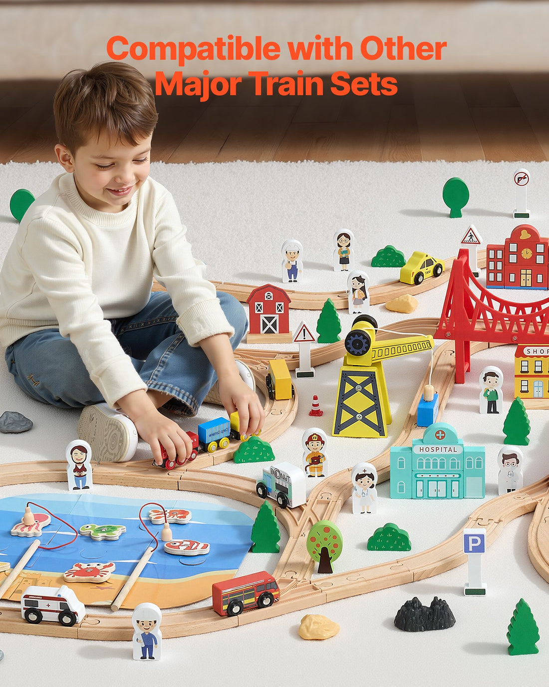 Boy playing with a large wooden train layout with bridges and buildings