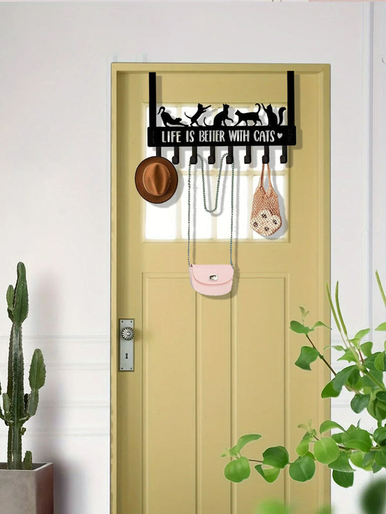 Cat hook rack over a yellow door holding a hat and bag